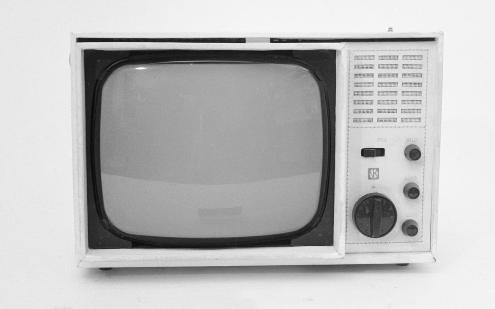 Svartvitt foto av en liten ljus tv-apparat med rundade hörn och vred på sidan