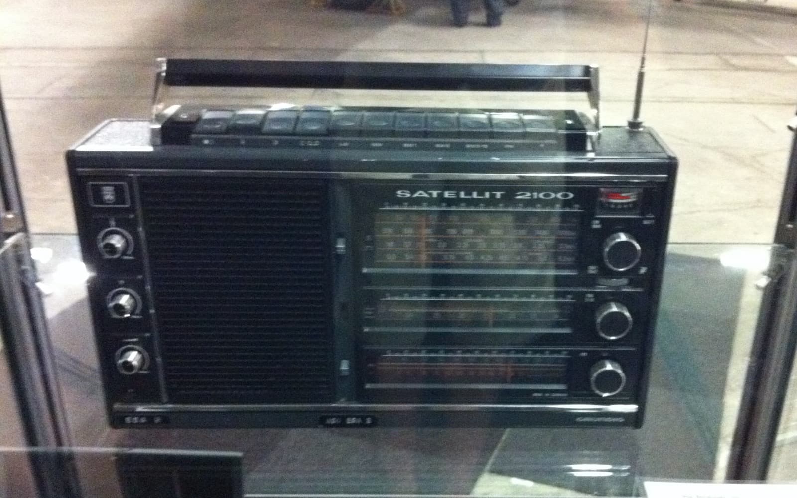 Svart kortvågsradio av märket Grundig Satellit 2100 i en glasmonter