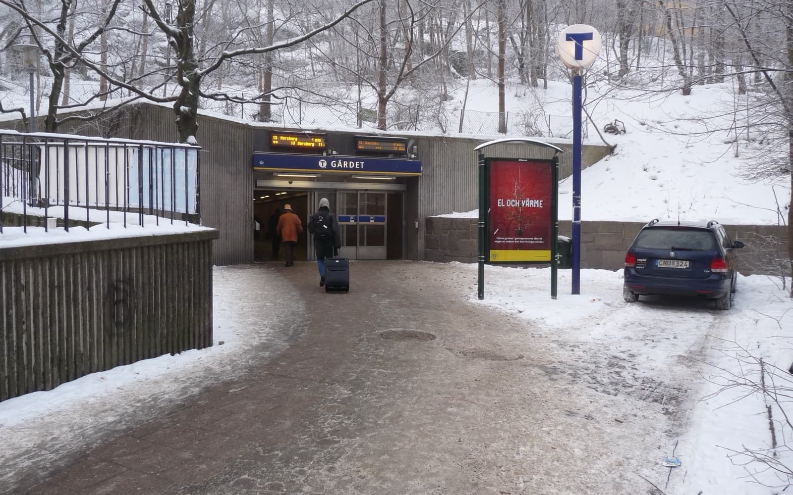 Entrén till tunnelbanestationen Gärdet en vinterdag, med snö på marken och kala träd