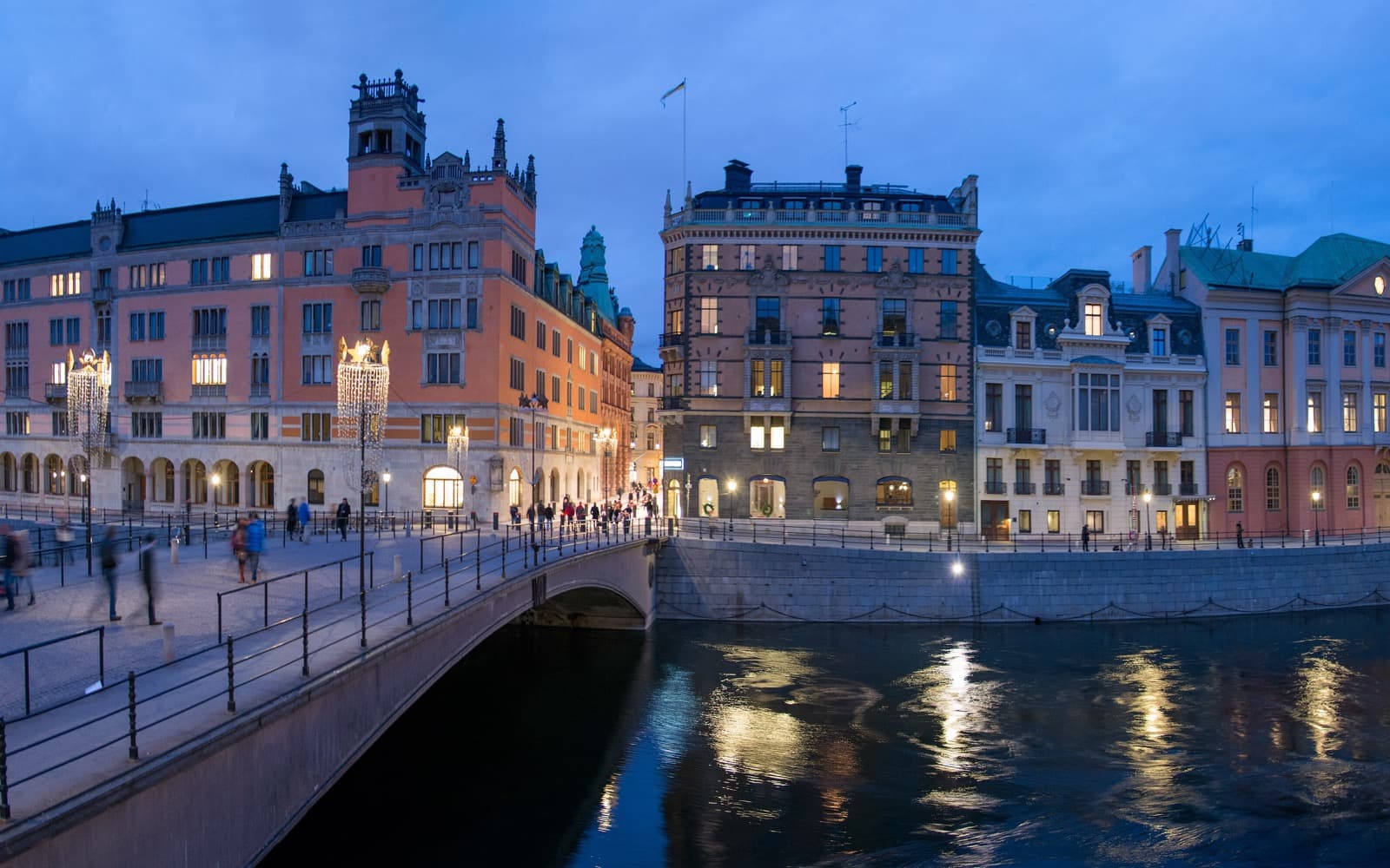 Riksbron i Stockholm en kväll, med upplysta gamla byggnader längs vattnet